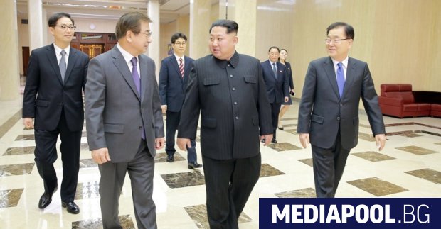Докато се ръкува с представител на пристигналата на посещение южнокорейска