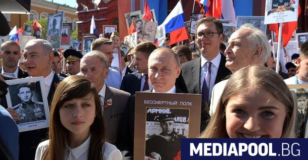 Владимир Путин в средата със снимка в ръце по време