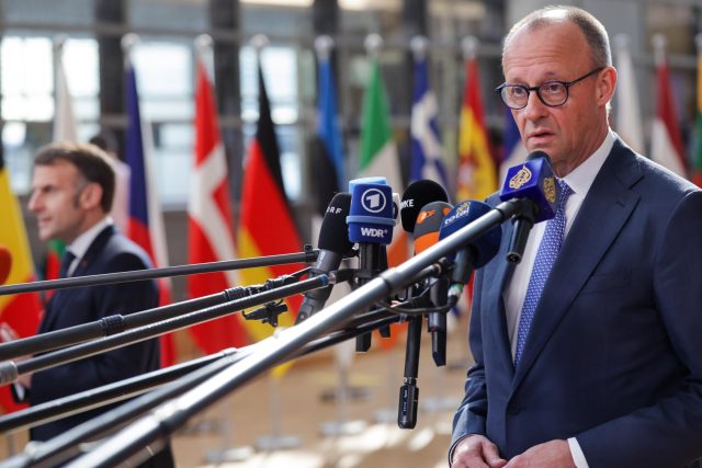 Канцлерът на Германия Фридрих Мерц и френският президент Еманюел Макрон (в дъното) при пристигането си за заседанието в Брюксел