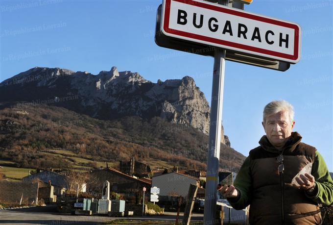 Кметът на село Бюгараш пред табелата му в очакване на наплив от туристи