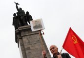 Цветя, червени знамена и портретът на Сталин пред Паметника на съветската армия