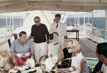 Снимка от борда на яхтата, направена през 1963 година, на която се виждат самият Онасис (прав посредата), Джаки Кенеди (със забрадка) и Франклин Рузвелт-младши (вляво), сина на бившия президент на САЩ Франклин Рузвелт