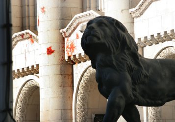 Лъвът на Съдебната палата в София на фона на оцапаната с домати фасада 