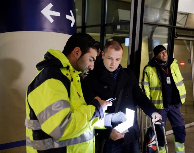 Служител на сигурността проверява паспорта на пътник на жп гарата на копенхагенското международно летище Каструп
