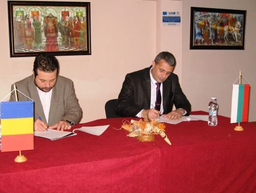 Морару (вляво) и Тодоров подписват документа.