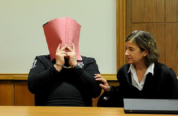 Обвиняемият Нилс Хьогел крие лицето си по време на процеса срещу него