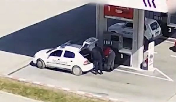 Кадър как полицаите преточват горивото от служебните коли