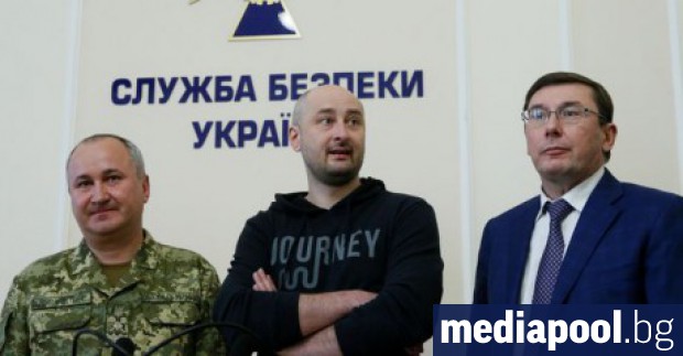 Аркадий Бабченко в средата по време на пресконференцията в сряда