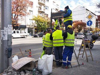 Шестима работници монтират едно от новите табла за градския транспорт в София. За целта те махнаха част от настилката от тротоара на бул. Дондуков". Този участък беше ремонтиран основно само преди година. Сн. Mediapool