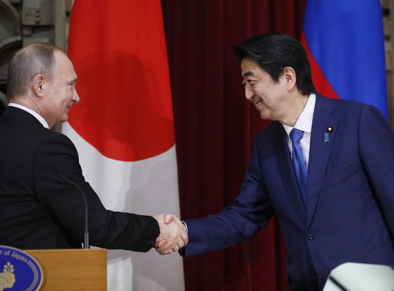 Шиндзо Абе (дясно) се ръкува с Владимир Путин