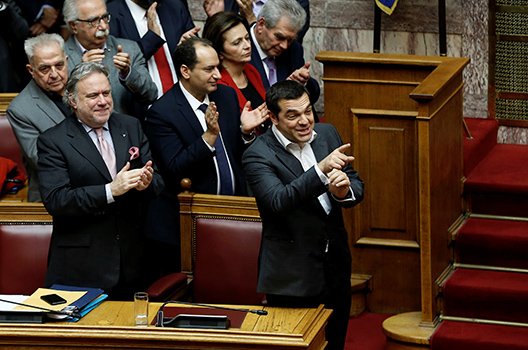 Премиерът Алексис Ципрас и министрите му аплодират резултата от гласуването. 