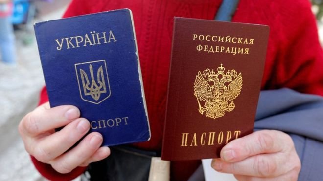 Жена в Крим държи украинския си паспорт (в синьо) и руския. 