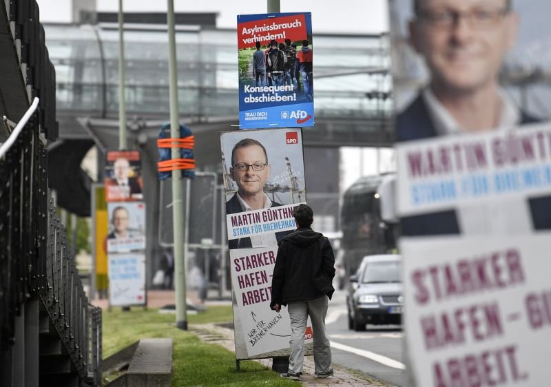 Избирател в германския град Бремерхафен е застанал пред предизборните плаката ин социалдемократите и Алтернатива за Германия