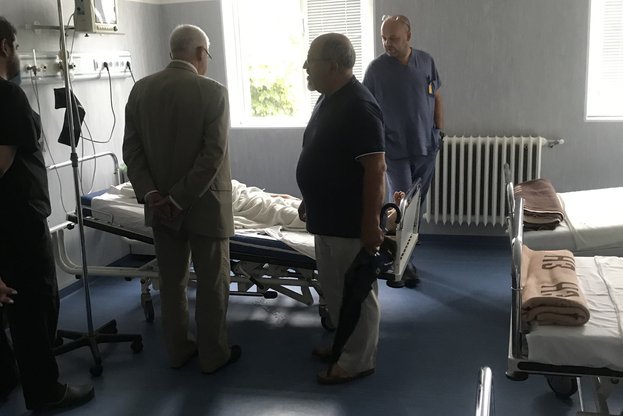 Здравният министър Кирил Ананиев над леглото на пациент в болница.
