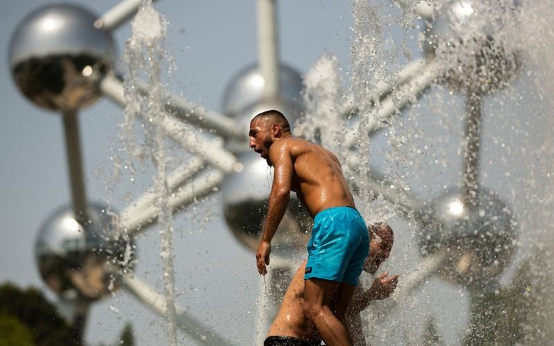 Мъж се охлажда във фонтана край прочутия Атомиум в Брюксел