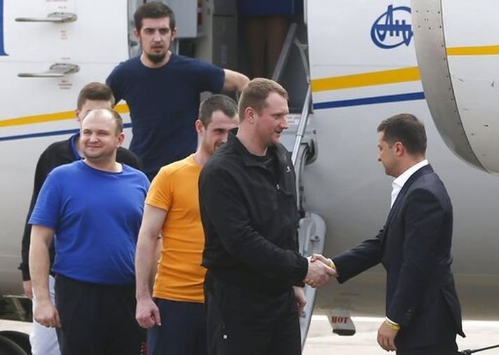 Зеленски (дясно) посреща затворниците на летището в Киев