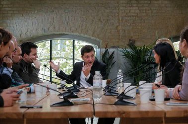 Володимир Зеленски (в средата) отговаря на поредната група журналисти, които през целия ден в четвъртък се изреждаха да показаната на снимката маса.