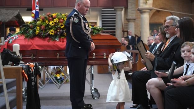 Малката Шарлот сложи каската на загиналия си баща по време на погребението му, сн. ЕПА