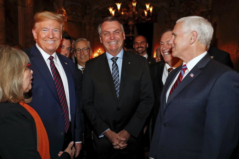 Болсонаро заедно с Тръмп и вицепрезидента Пенс по време на вечеря във Флорида на 7 март. Зад гърба на Тръмп частично се вижда лицето на говорителя Фабио Вайнгартен