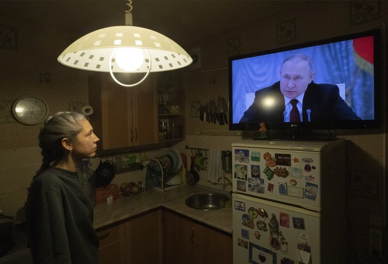 Жена в Санкт Петербург гледа изявление на Путин по телевизията. ЕПА/БГНЕС