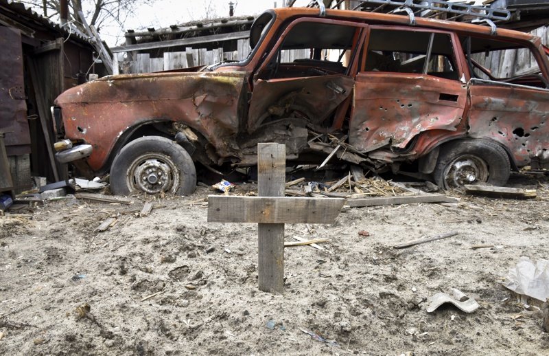 Маркиран с дървен кръст гроб в двор в киевското предградие Гостомел, Сн. ЕПА/БГНЕС