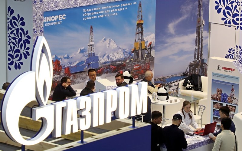 Логото на руската компания "Газпром" и постер на Китайската петролна и химическа корпорация (Sinopec) по време на международно изложение в Москва през април 2022 г. Снимка ЕПА/БГНЕС
