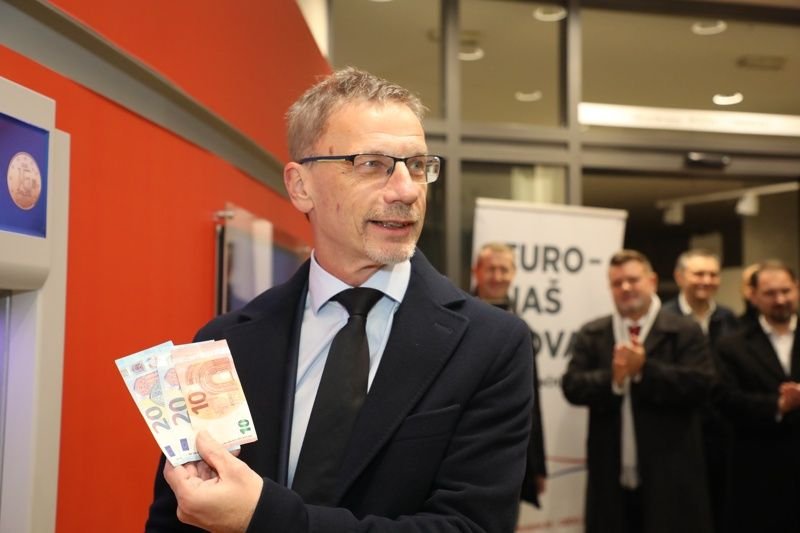 Управителят на хърватската централна банка Борис Вуйчич показва новите евробанкноти на банкомат в Загреб, след като страната му влезе в еврозоната на 1 януари. Снимка: ЕПА/БГНЕС