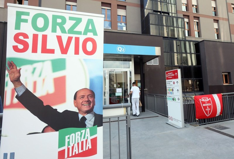 Плакат в подкрепа на Силвио Берлускони, поставен на входа на болницата Сан Рафаеле, Сн. ЕПА/БГНЕС