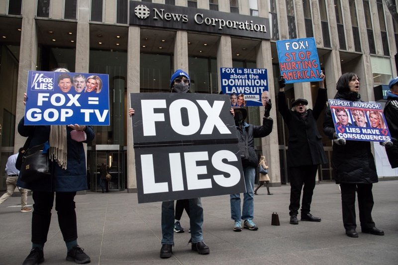 Граждани протестират пред централата на Fox News в Ню Йорк през февруари тази година с плакати "Fox лъже", "Лъжите имат последствия" и др. Снимка: ЕПА/БГНЕС