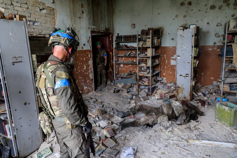 Украински военнослужещи попадат на мъртъв руски войник в разрушена сграда на наскоро освободеното село Благодатне, Донецка област, Украйна, 17 юни 2023 г. ЕПА/БГНЕС