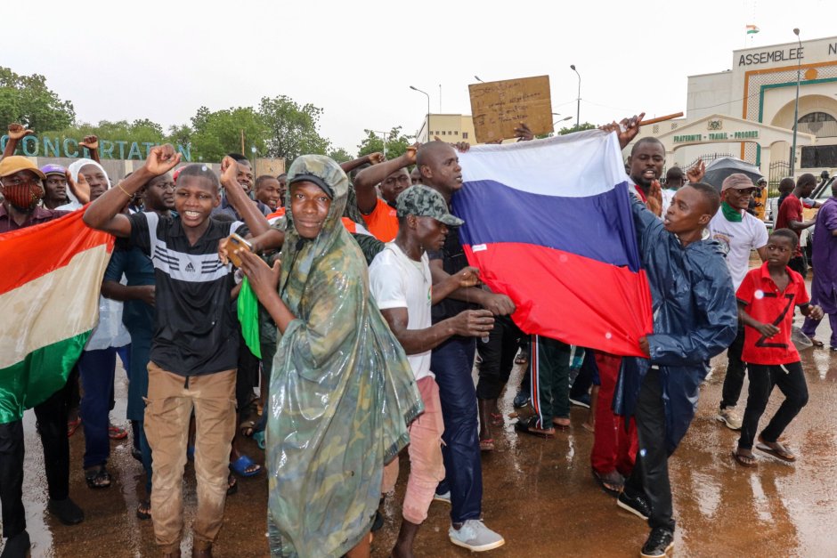 Поддръжници на военния преврат държат знамената на Нигер и Русия, докато празнуват пред сградата на Народното събрание в Ниамей, Нигер на 27 юли, Сн. ЕПА/БГНЕС 