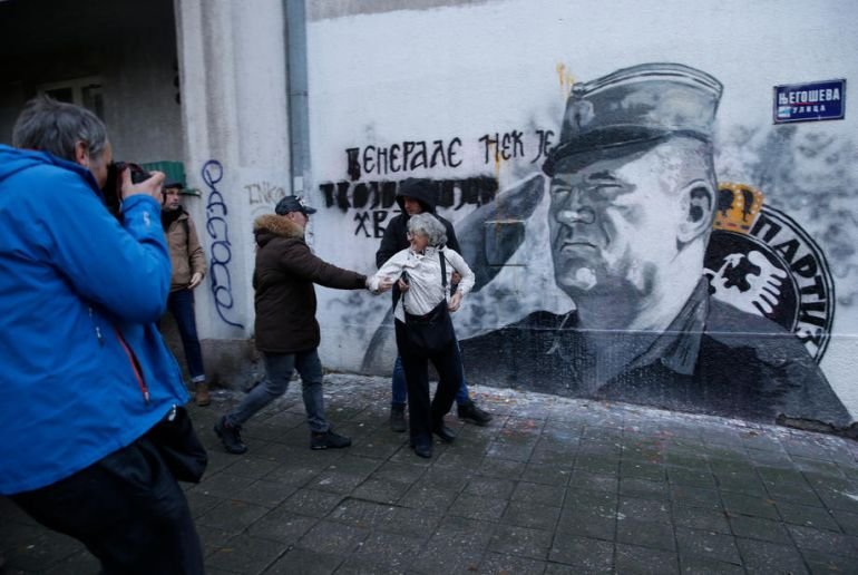 Аида Чорович хвърля яйца по стенописа на Ратко Младич върху блок в Белград през 2021 г. Сн. ЕПА/БГНЕС