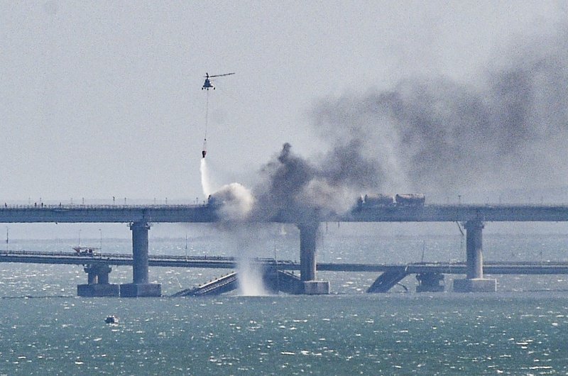 Пожарникарски хеликоптер излива вода върху огъня на срутена част от моста над Керченския проток в Крим след атаката срещу него, 08 октомври 2022 г. Снимка: ЕПА/БГНЕС
