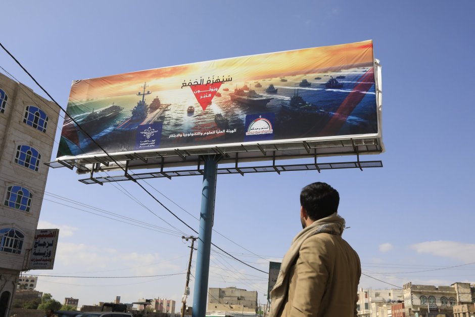 Билборд в йеменската столица Сана, на който са изобразени бойни кораби и надпис "Тълпата ще бъде победена". Йеменските хуси нанасят удари срещу търговските кораби в Червено море от ноември 2023 г. Снимка: ЕПА/БГНЕС