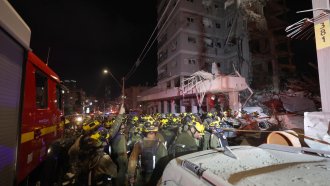 Израелски спасителни екипи работят на мястото, където ирански балистични ракети удариха жилищни сгради в Бат Ям, близо до Тел Авивл.  Сн. EPA/ATEF SAFADI