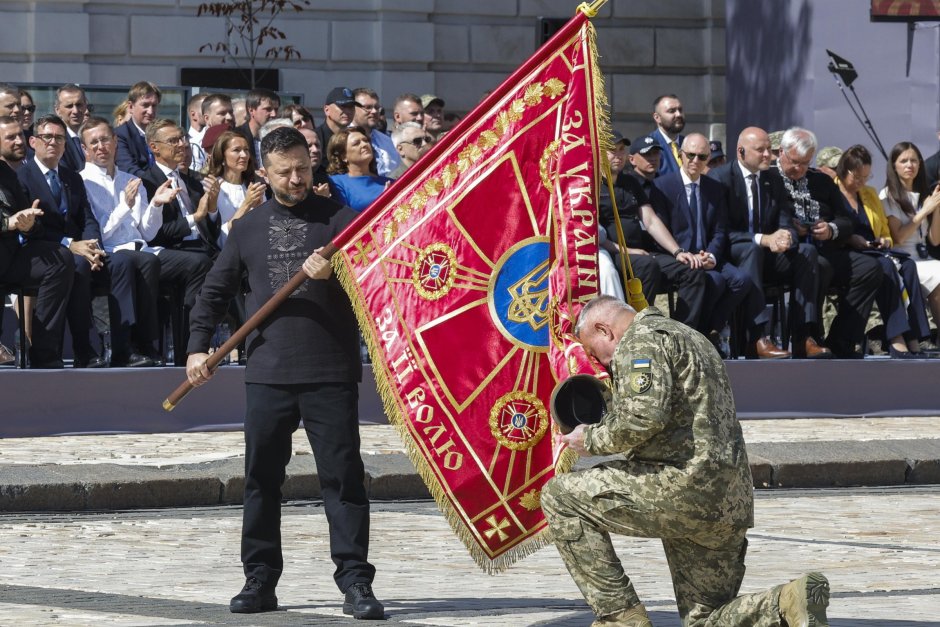 Украинският президент Володимир Зеленски (вляво) връчва знамето на представител на едно от украинските подразделения по време на събитие по случай Деня на независимостта на Украйна близо до катедралата "Света София“ в Киев, сн. ЕПА/БГНЕС